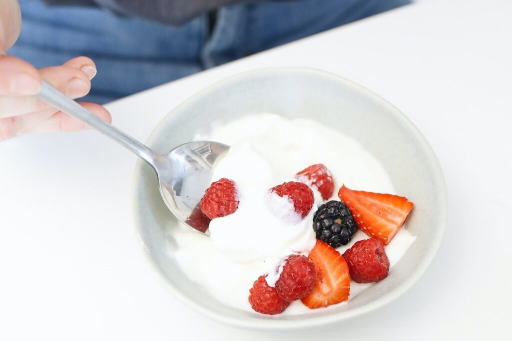 A bowl filled with coconut cream and berries. Image source: Pexels