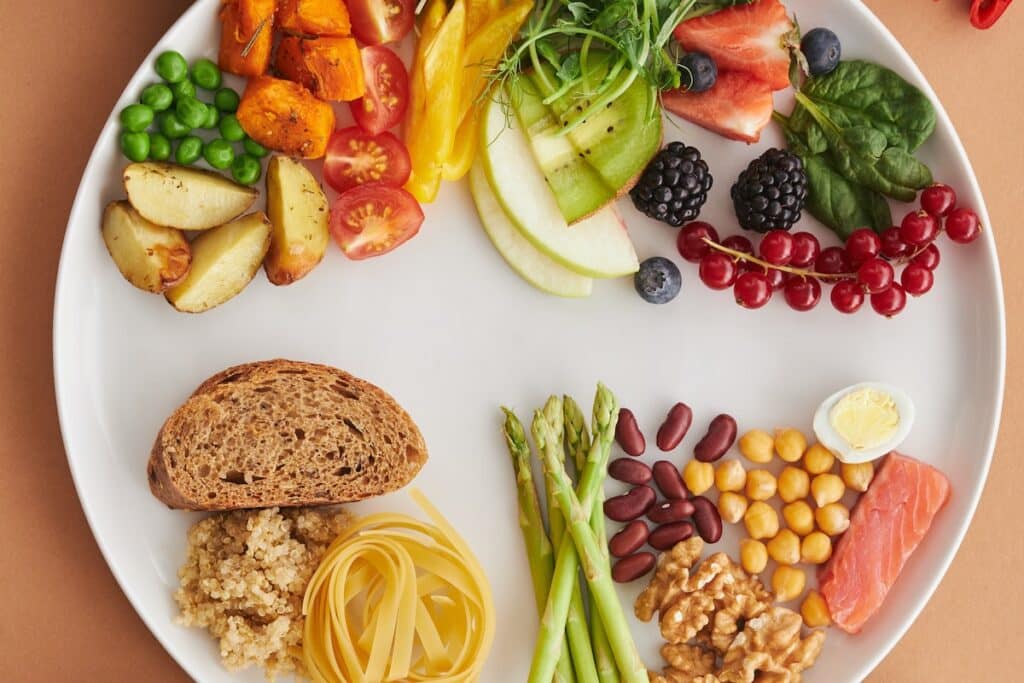 A plate full of nuts fruits and vegetables. Source: Pexels